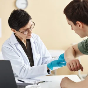 Doctor examining patient's elbow in office.