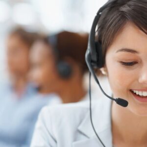 Smiling woman with headset assisting customers.